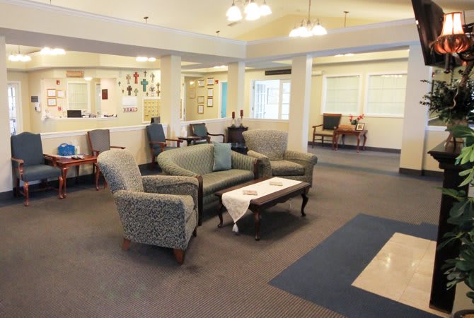 A comfortable and well-lit lobby area with sofas and chairs arranged around a central table.