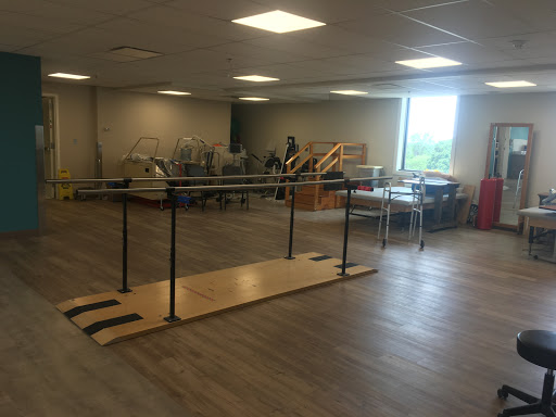 An empty dance studio featuring a ballet bar and various exercise equipment.