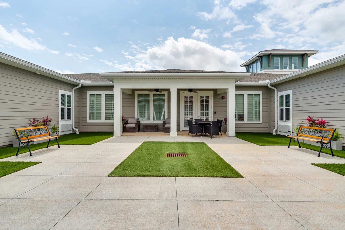 A modern house with a spacious courtyard and well-maintained lawn.