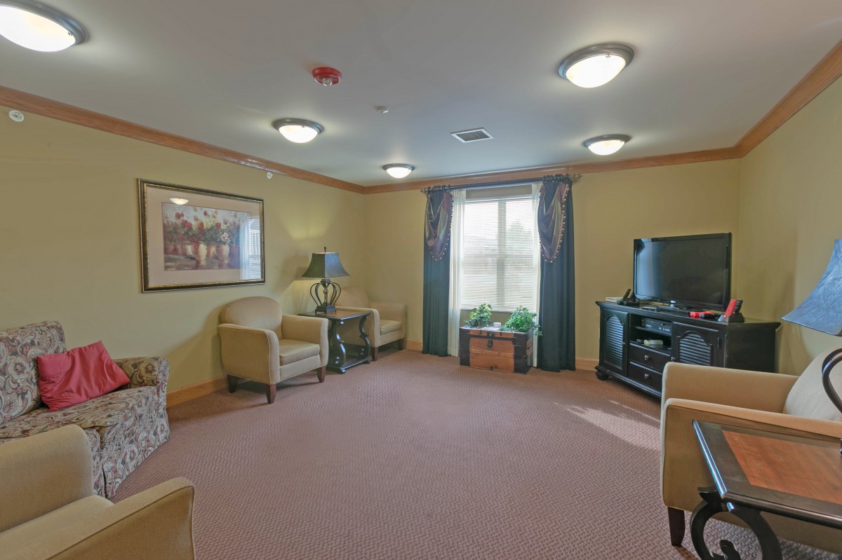 A cozy living room with comfortable seating, a TV unit, and soft lighting.