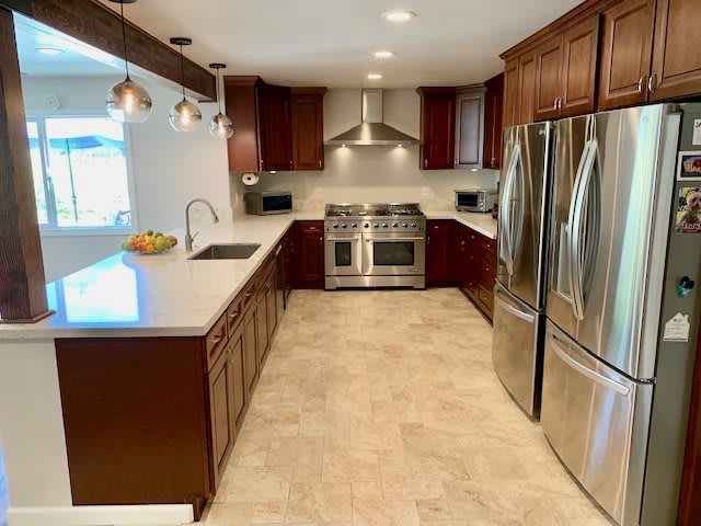 A modern kitchen with stainless steel appliances and wood cabinetry.