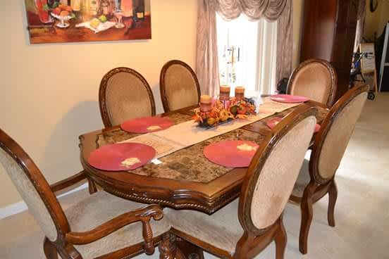 A classic dining room setup with a wooden table, matching chairs, and decorative placemats.