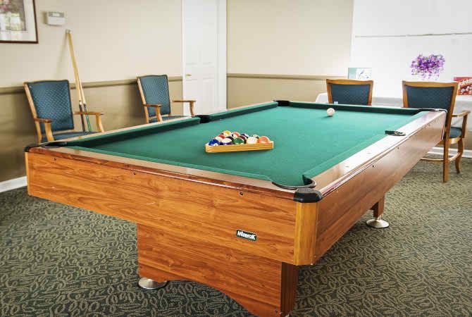 A billiards table set up in a well-lit game room.