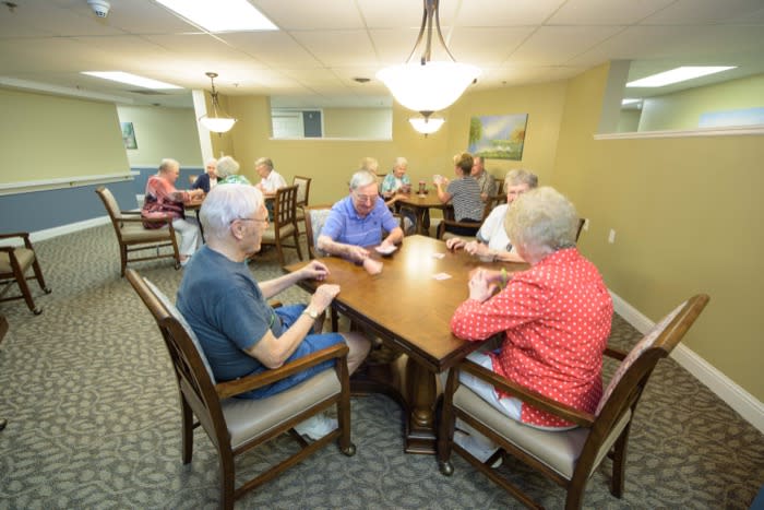 Seniors enjoying a card game in a community room.