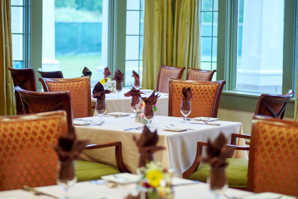 A well-arranged dining room with neatly set tables and elegant decor.