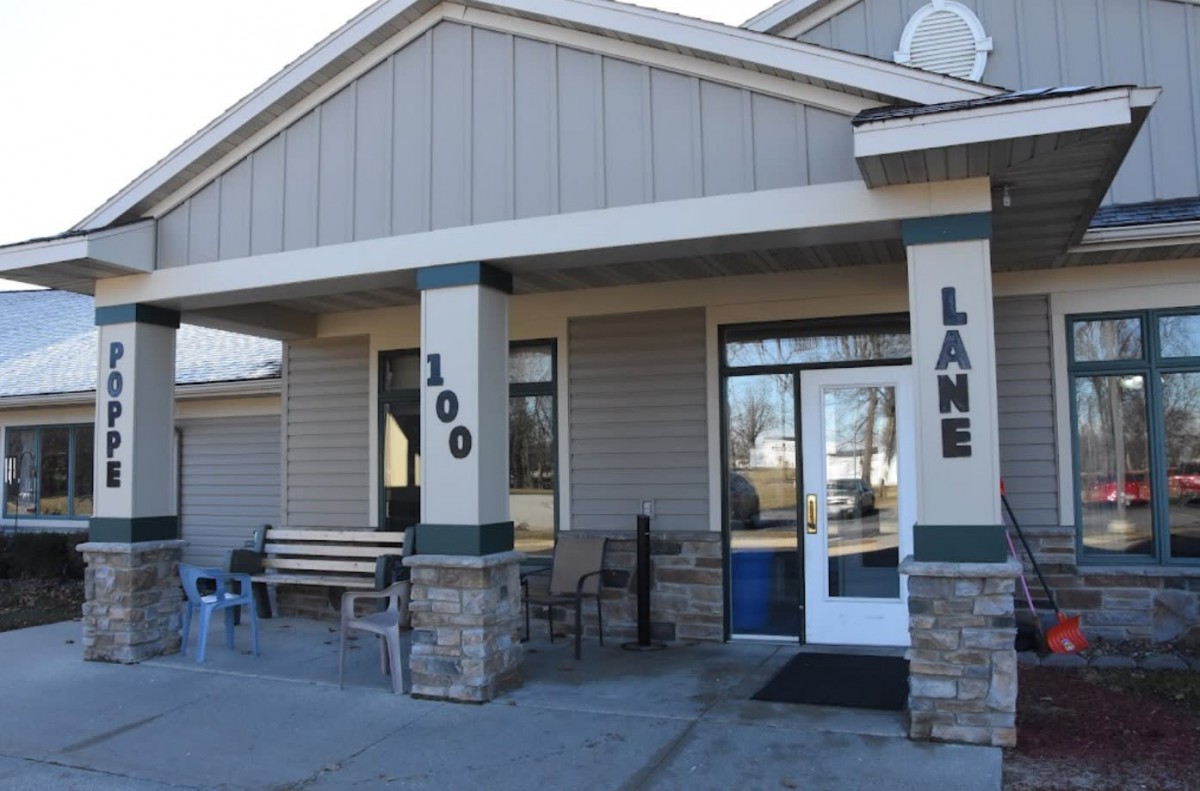 Entrance to a building with stone pillars and outdoor seating.
