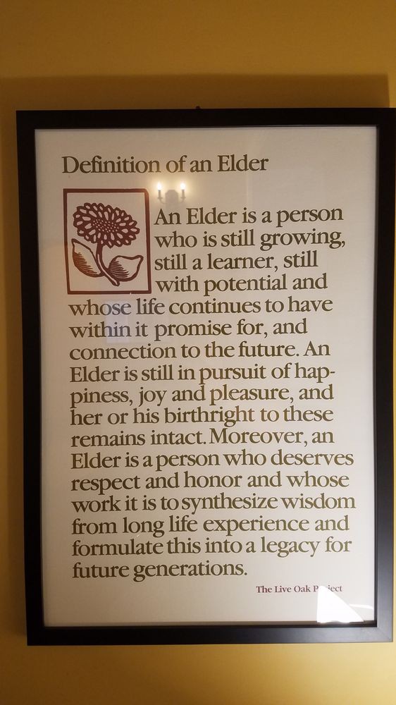 A framed poster defining an elder as a person who continues to grow, learn, and connect with the future.