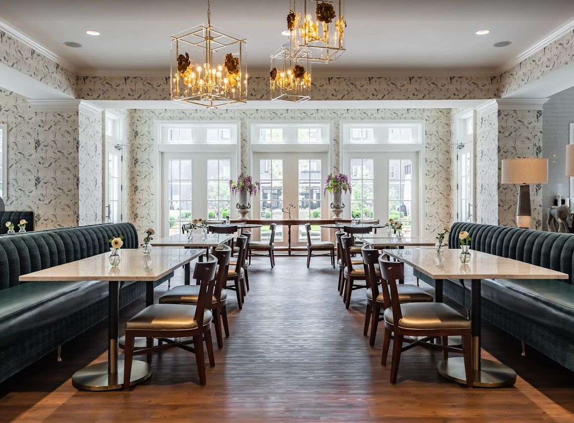 A beautifully designed restaurant dining area with elegant chandeliers and ample natural light.