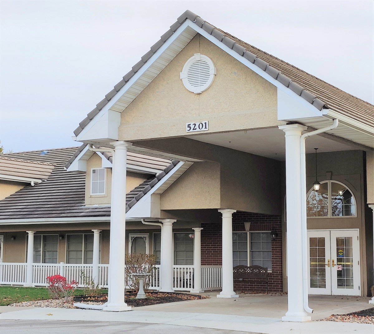 A building entrance with pillars and a triangular roof design.