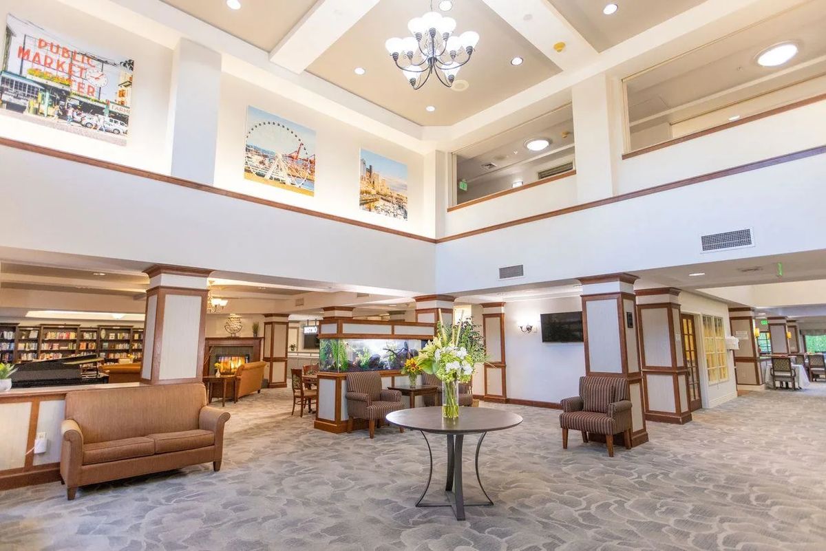 A spacious lobby with seating areas, a large chandelier, and decorative artwork on the walls.
