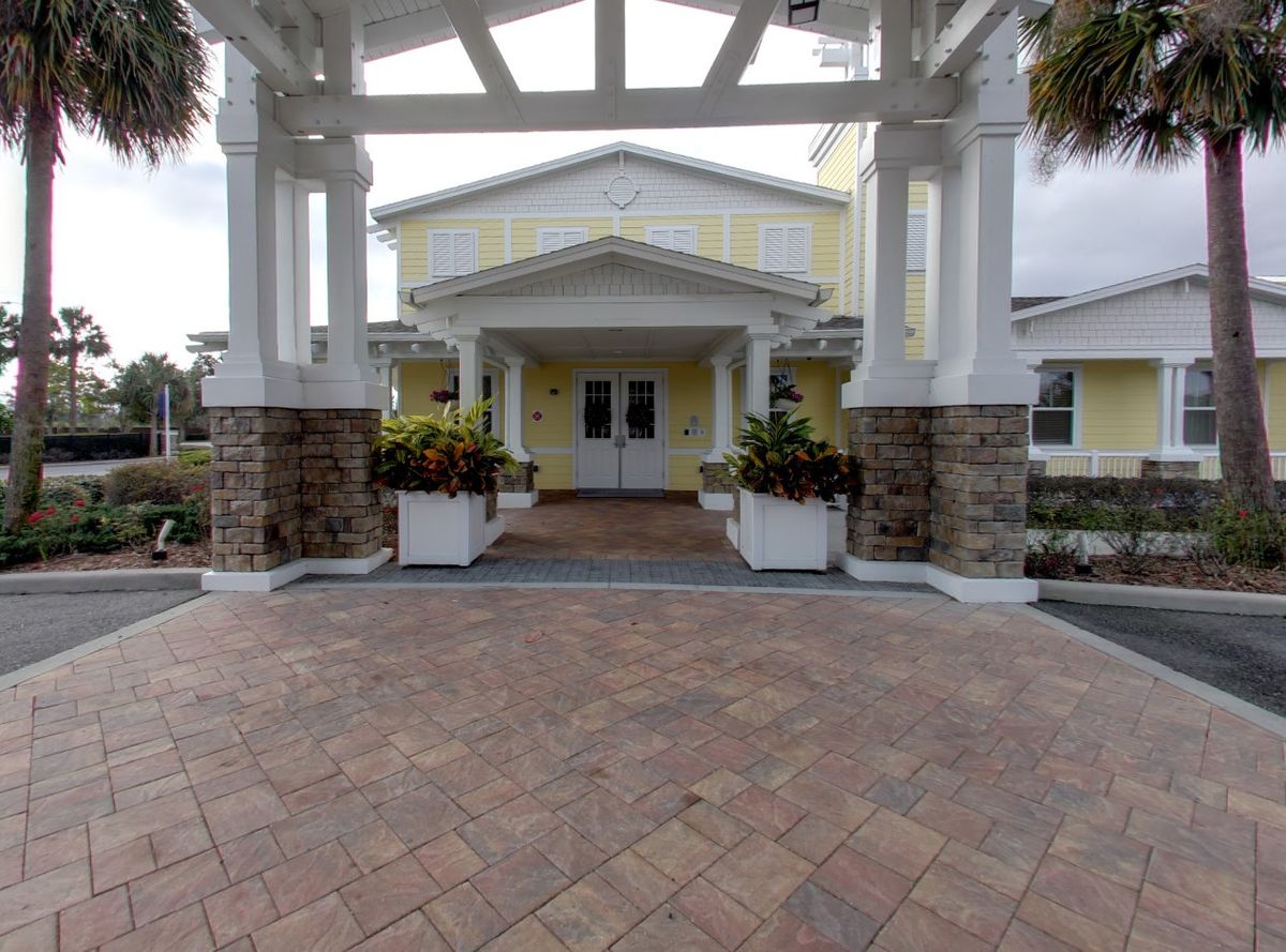 The entrance of a building featuring columns and stonework with planters.