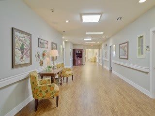 A well-lit hallway with seating and artwork on the walls.