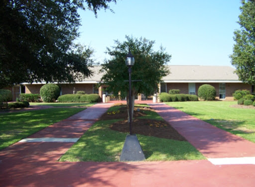 A serene outdoor space featuring pathways, well-maintained lawns, and surrounding trees.
