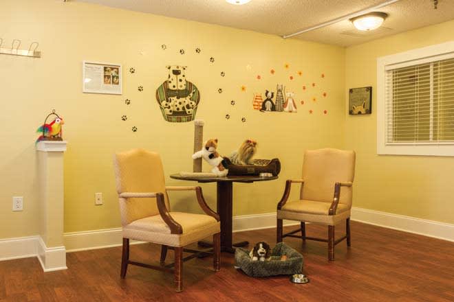 A cozy waiting room with two chairs, a small table, and decorative wall art.