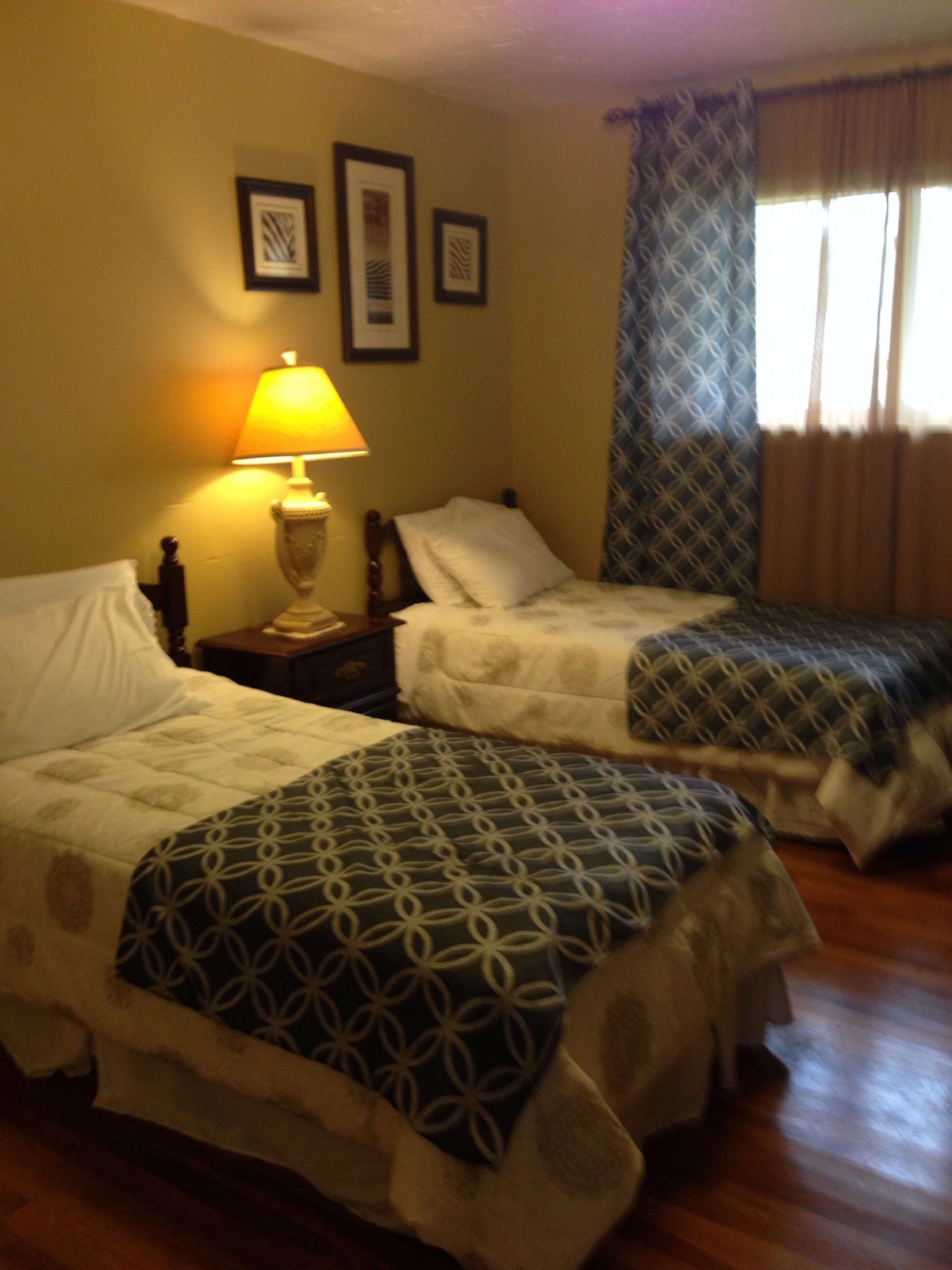 A cozy bedroom with twin beds and warm lighting.
