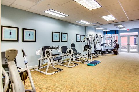 A spacious gym equipped with various exercise machines and workout areas.