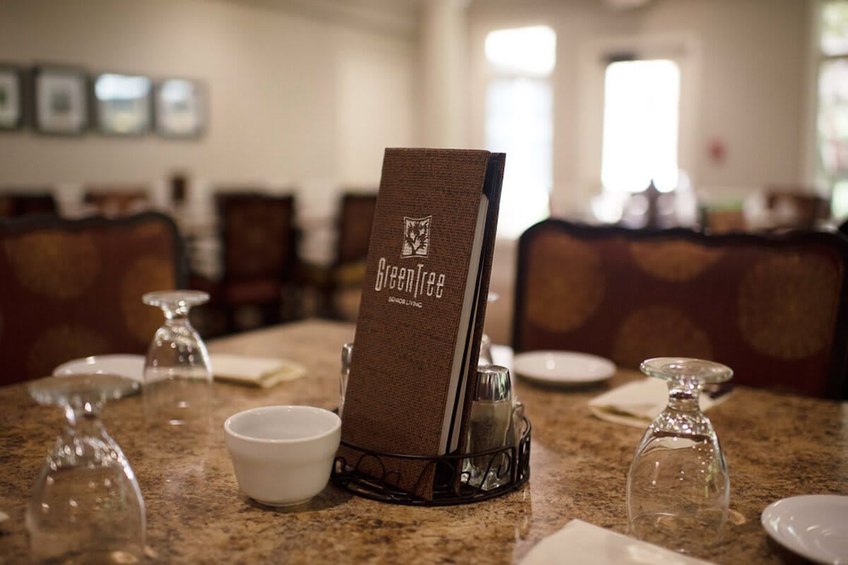 A neatly set dining table with a menu at a restaurant.