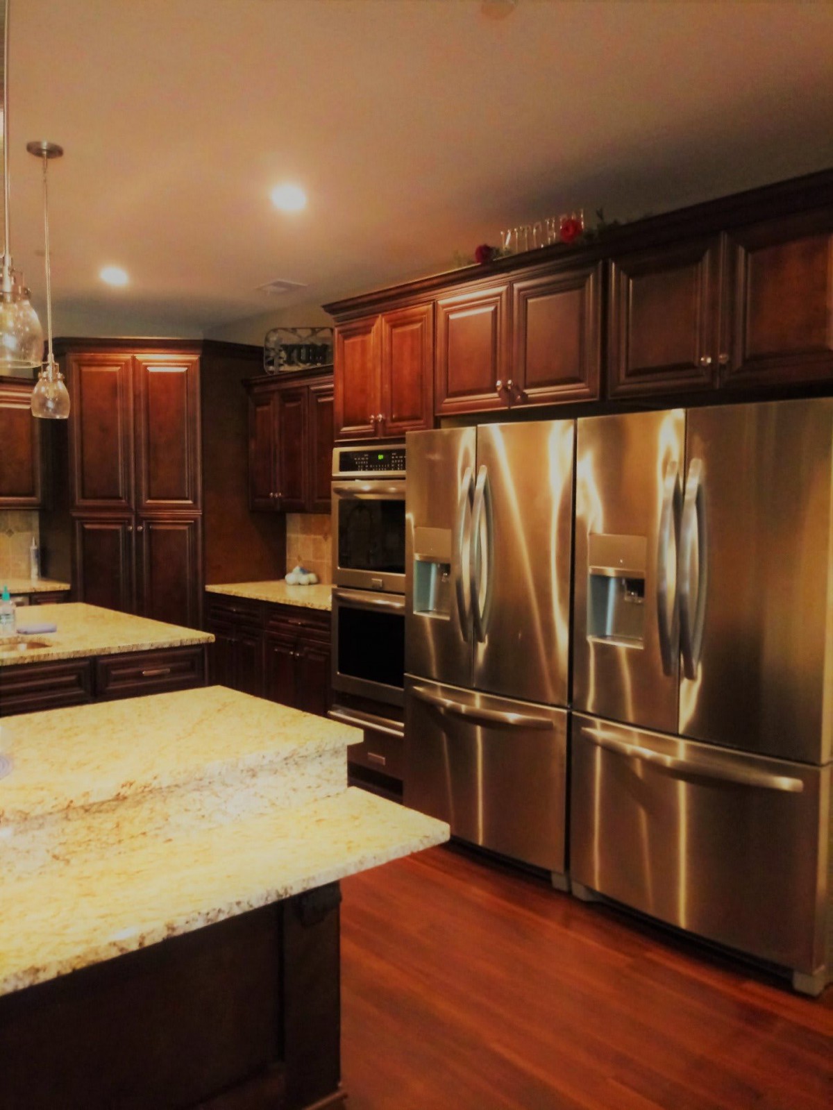 A modern kitchen featuring stainless steel appliances and granite countertops with wooden cabinets.