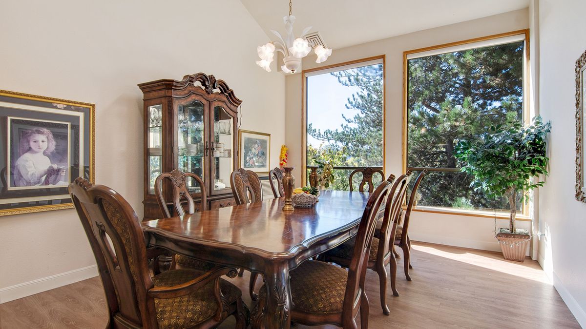 A classic dining room with wooden furniture and large windows letting in natural light.