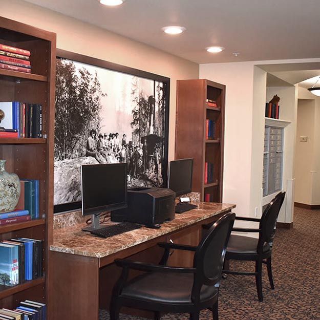 A well-organized workspace with computers, bookshelves, and chairs.