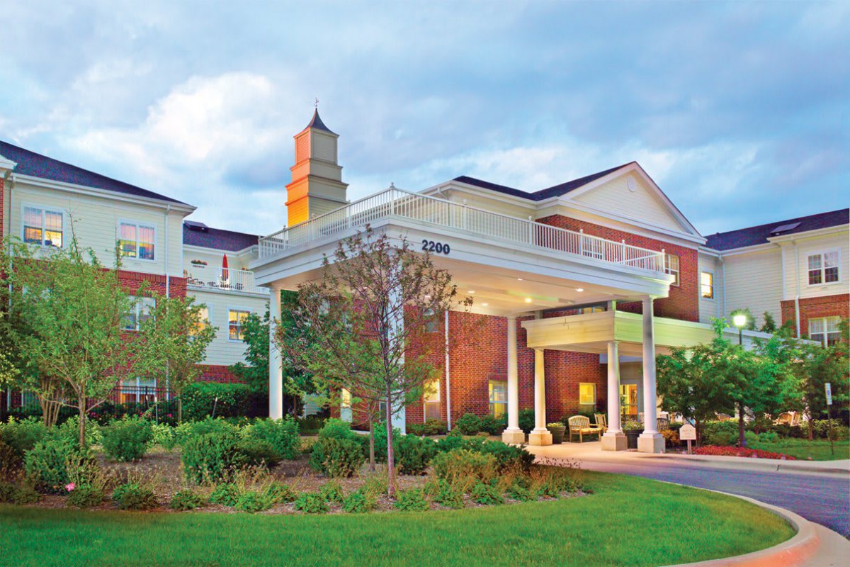 A beautifully designed building with a grand entrance and landscaped surroundings.