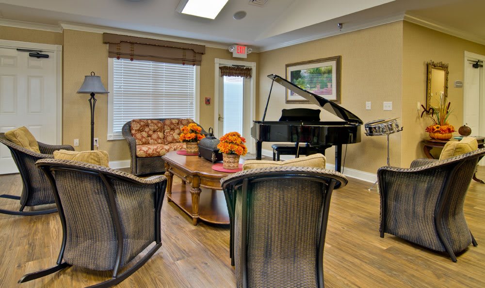A cozy living room with comfortable seating and a grand piano.