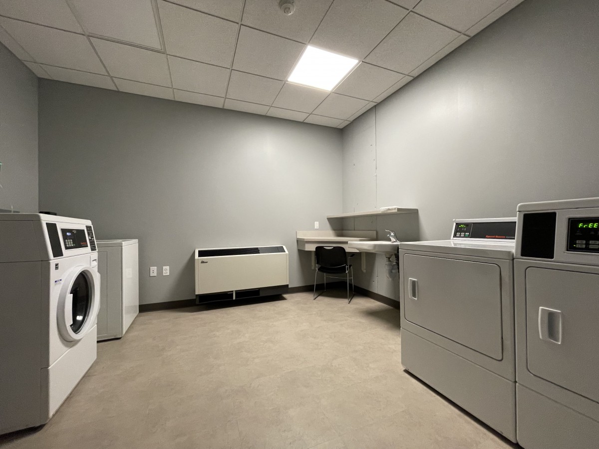 A minimalist laundry room with a washing machine and dryer against gray walls.