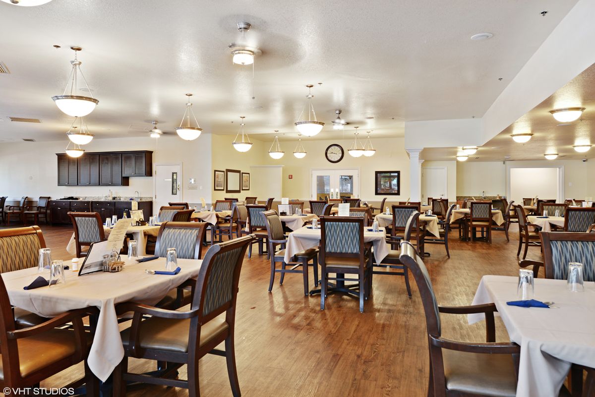A spacious and well-lit dining area with neatly arranged tables and chairs.
