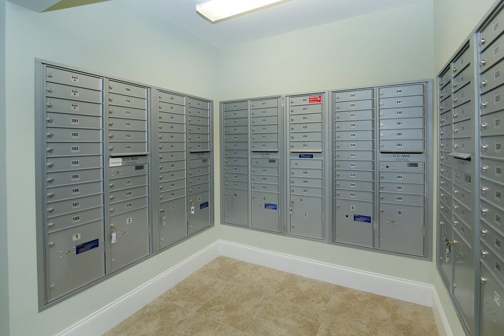 A mailroom with multiple metal mailboxes arranged along the walls.