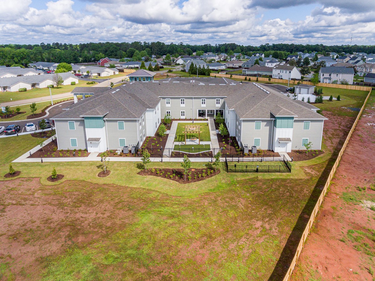 Aerial view of a suburban residential building surrounded by green spaces.