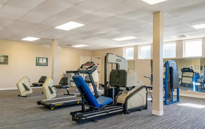 A spacious gym with various exercise machines and treadmills.