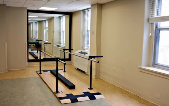 A rehabilitation room equipped with parallel bars for physical therapy exercises.