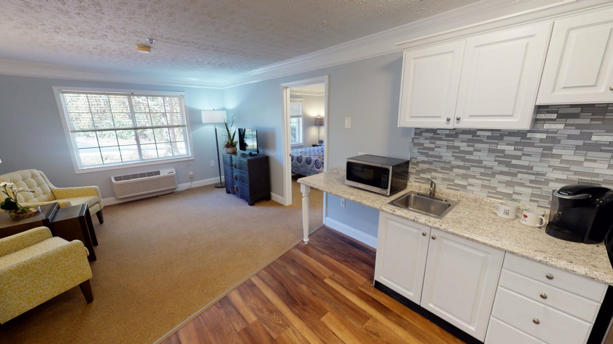 A cozy apartment living space with a kitchenette featuring a microwave.