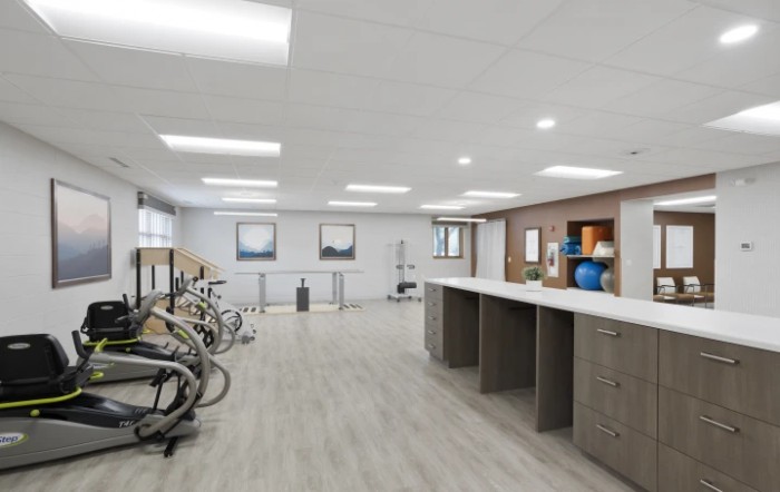 A modern rehabilitation gym with stationary bikes and ample space, designed for exercise and therapy activities.