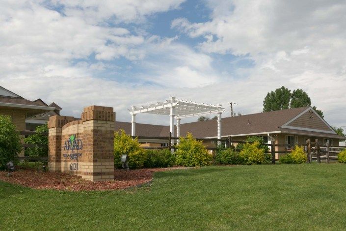 A building with a landscaped garden and a clear sky overhead.