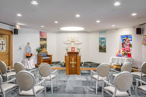 A serene chapel setting featuring an altar, seating for visitors, and religious artwork.
