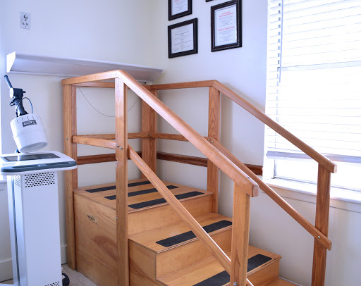 A wooden staircase with handrails, commonly used for rehabilitation exercises.