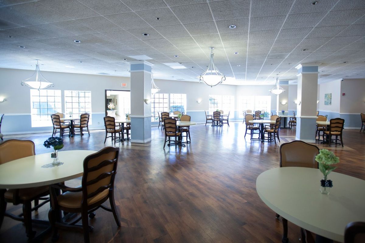 Spacious dining area with wooden floors and elegant lighting.
