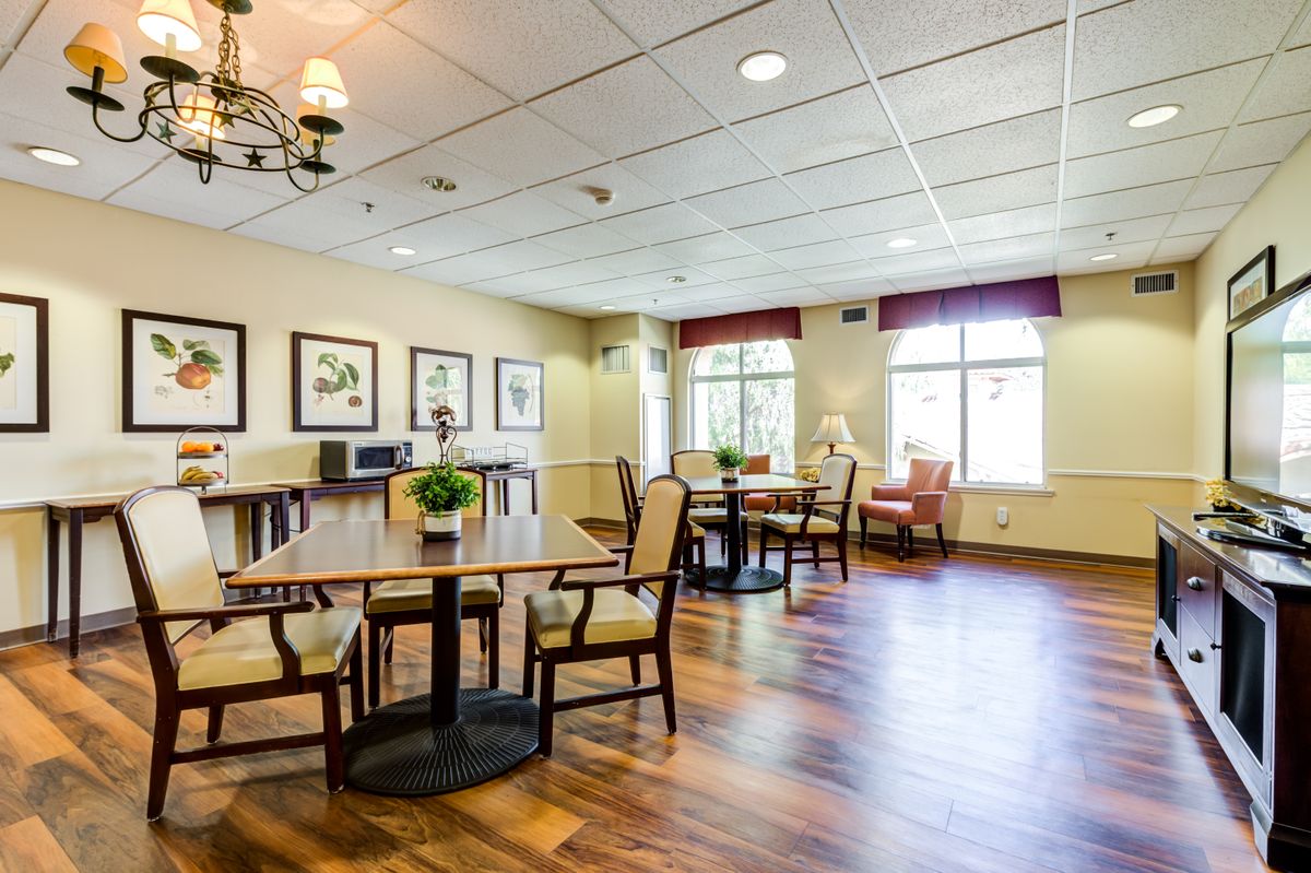A bright and spacious dining area with tables, chairs, and decorative artwork on the walls.