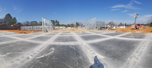 Construction site showing the framework for a new building under a clear blue sky.