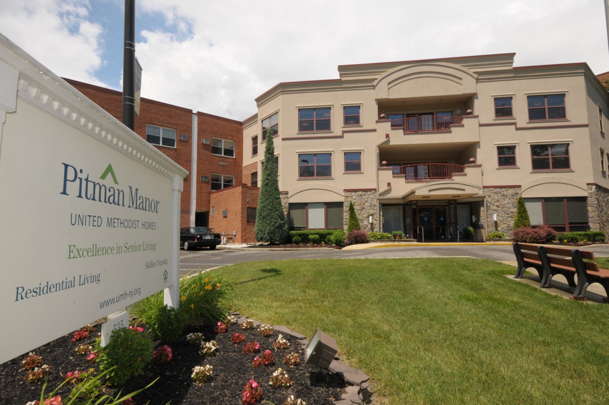 A hospital building with a sign and landscaped surroundings.