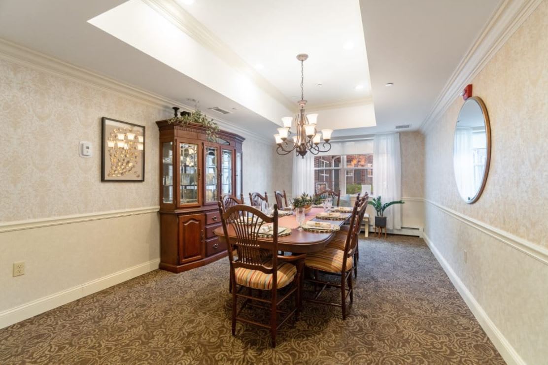 A well-furnished dining room with a large table and chandelier.