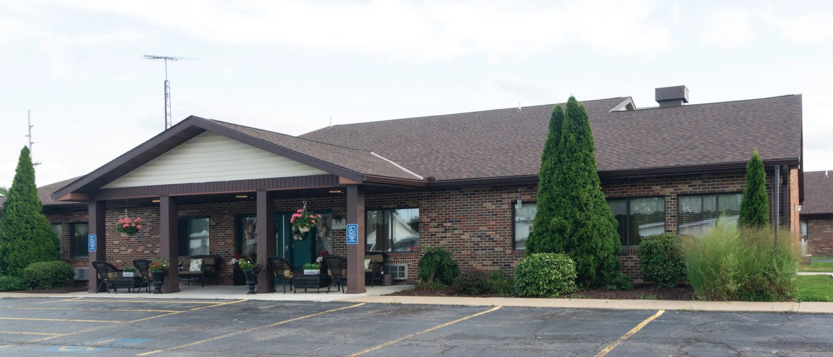 Exterior view of a brick restaurant with a parking lot and landscaping.