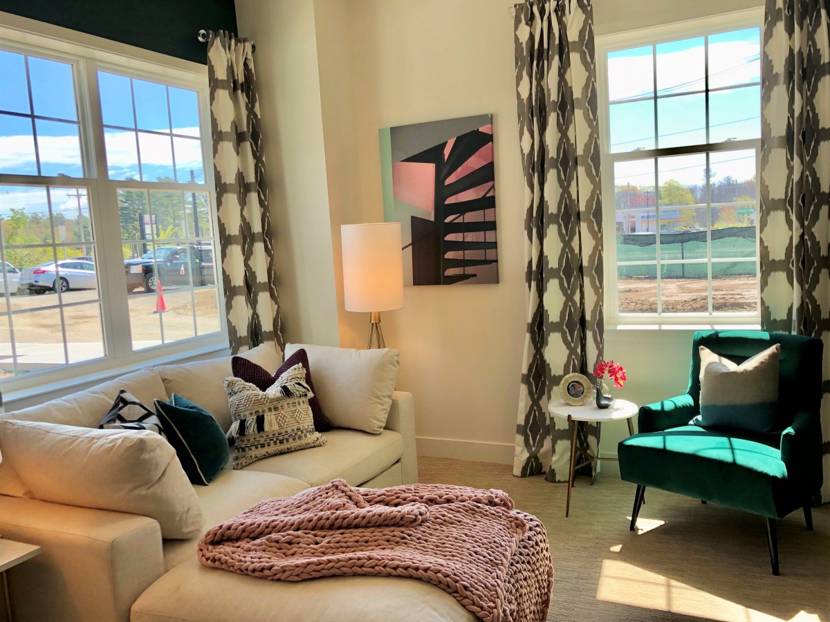A cozy and modern living room with a comfortable sofa, stylish armchair, and large windows letting in natural light.