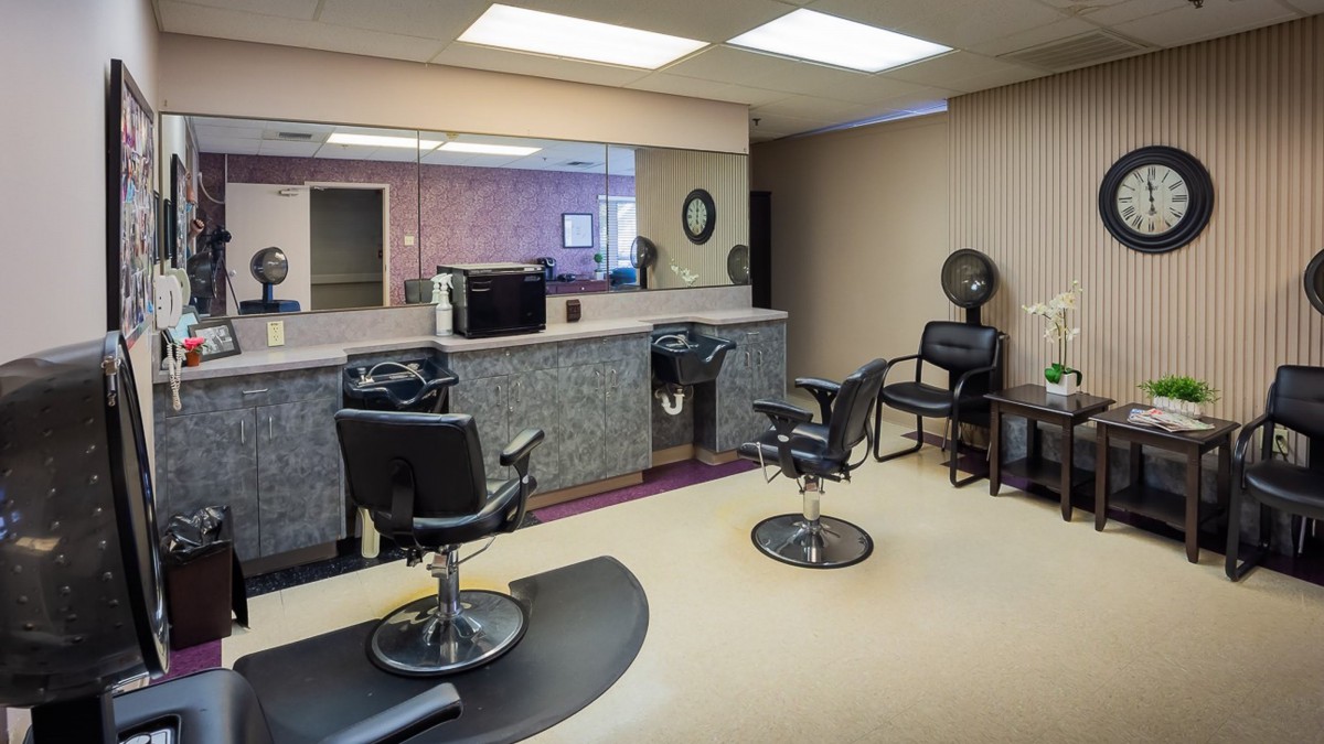 An empty hair salon with styling chairs and mirrors.