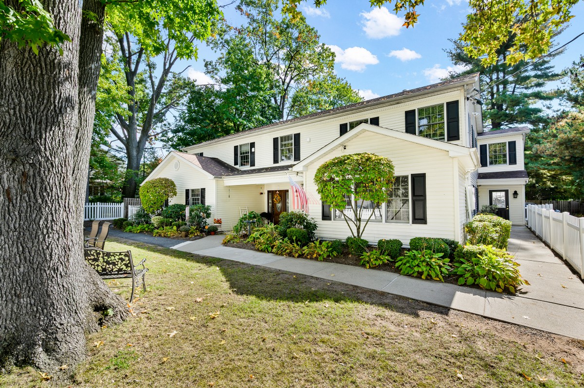 A charming suburban house with a well-maintained garden and lawn.