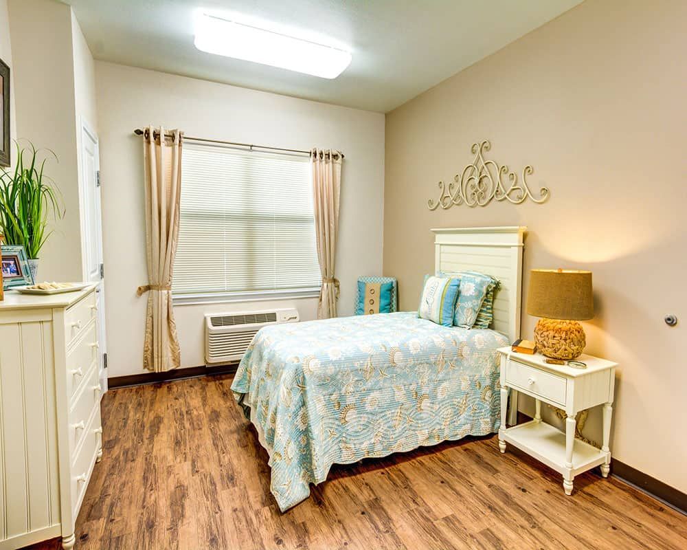 A cozy bedroom with a single bed, elegant curtains, and warm lighting.