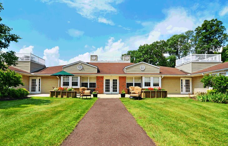 A suburban house with a well-maintained lawn and clear skies.