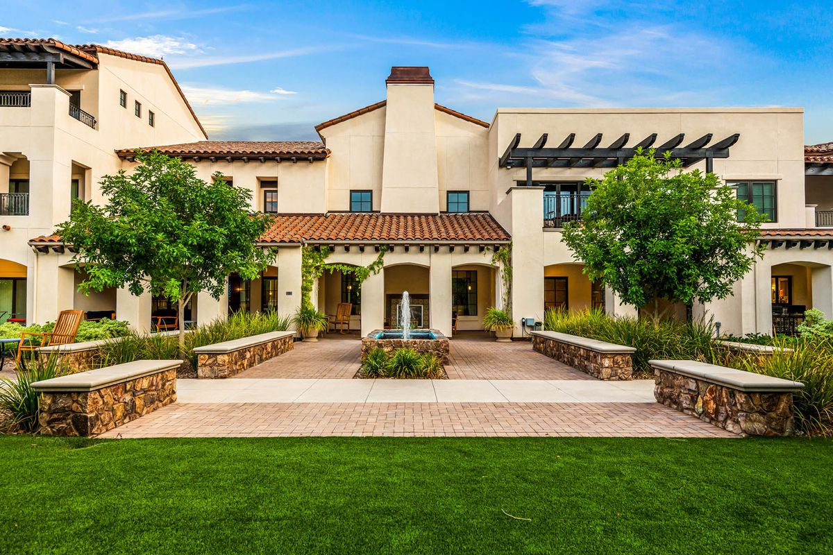 A beautiful Mediterranean-style house with a well-maintained garden and central fountain.