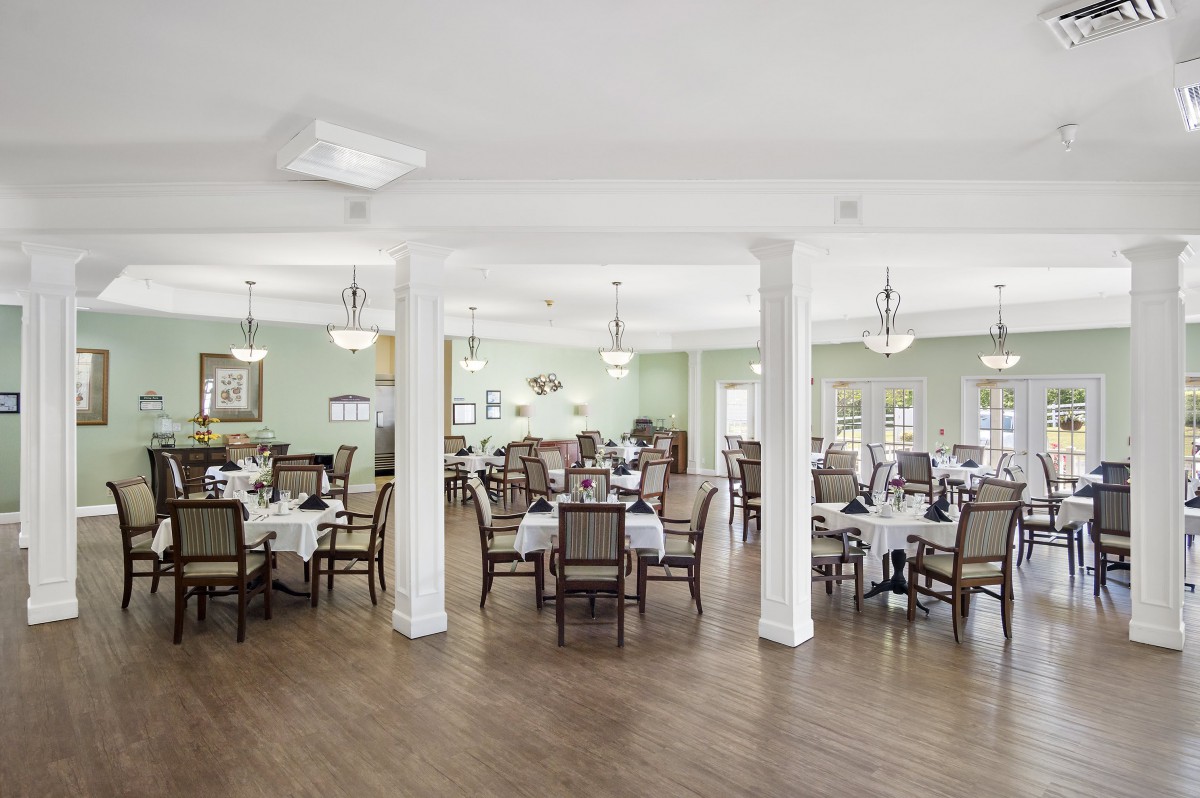 A spacious and elegantly decorated dining area with neatly arranged tables and chairs.